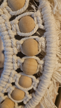 Houten macramékralen in macramé kunstwerk